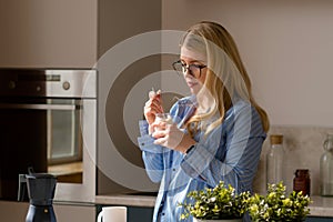 Woman tasting yogurt in sunlit kitchen