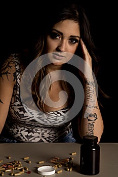 Woman with tattoos with drugs look serious