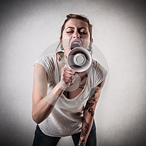Woman with tattoos using a megaphone photo
