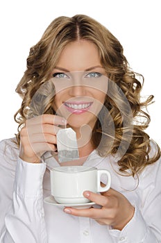 Woman with tea bag and cup in hand