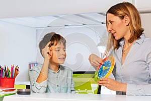 Woman teach boy with autism clock and hours photo