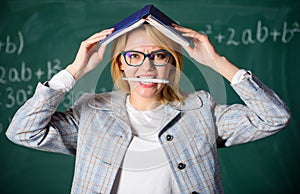 Woman teacher with book as roof on head. Memorizing method. Train memory every day. Effective method to remember