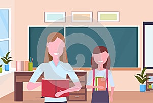 Woman teacher with schoolgirl pupil standing over chalkboard modern school classroom interior female cartoon characters