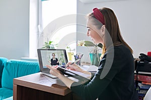 Woman teacher teaching student teenager online using video call on laptop