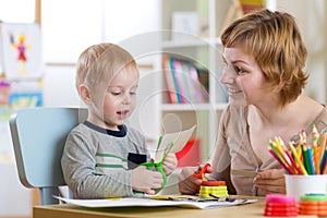 Woman teaches child handcraft