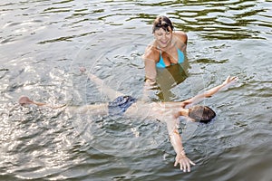 Woman teaches the child to stay on the water in the Lake