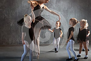 Woman teaches girls to dance ballet