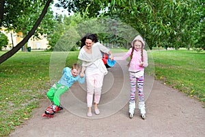 A woman teaches to make the first steps on roller skates childre