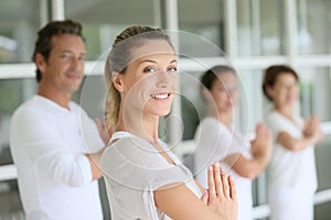 Woman teaching yoga to the group of people