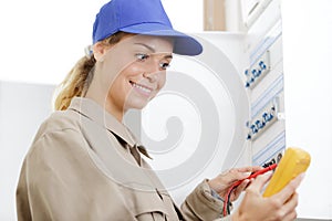 woman technician reading voltage fuseboad meter