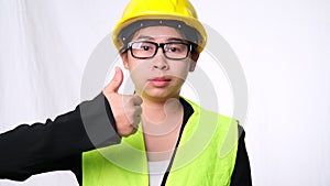 Woman technician smiling with helmet and showing thumbs up. Confident woman construction worker on white background in studio.