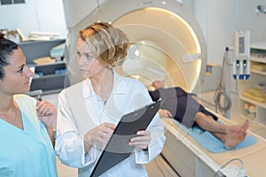 Woman technologists talking near patient in mri