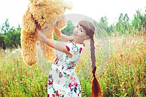 Woman with a Teddy bear in nature