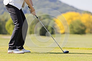 Woman teeing off, close up.