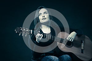 Woman teen girl with guitar on black