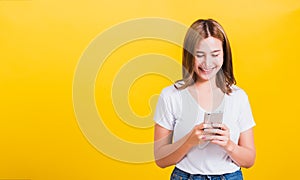 Woman teen smile standing playing game or writing message on smartphone