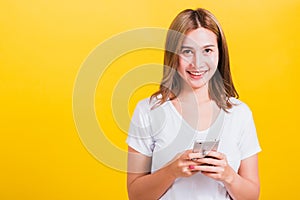 Woman teen smile standing playing game or writing message on smartphone