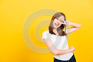 Woman teen smile standing wear t-shirt showing finger making v-sign symbol near eye