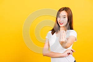 Woman teen smile standing wear white t-shirt making gesture hand inviting to come