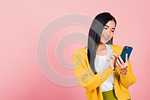 Woman teen smiling excited typing text message on smart mobile phone