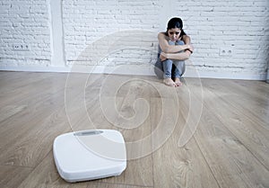 Woman or teenager girl sitting on ground alone worried at home