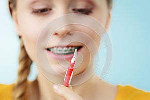 Woman with teeth braces using interdental brush