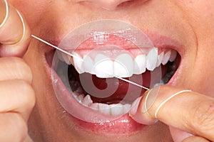 Woman teeth with dental floss.