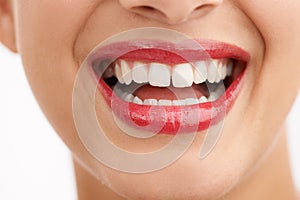 Woman, teeth and red lipstick with makeup for beauty, cosmetics or dental care on a white studio background. Closeup of