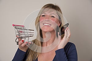 Woman with telephone holding a supermarket trolley