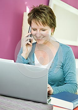 Woman with telephone and notebook computer