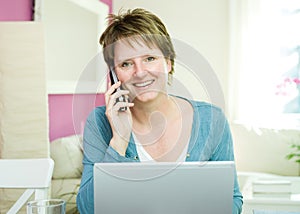 Woman with telephone and notebook computer