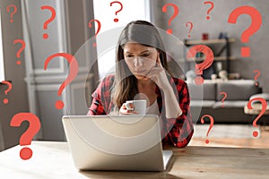 Woman teleworker works at home with a laptop but has some questions photo