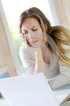 Woman teleworking on laptop getting upset photo