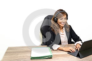 woman teleworking in office with her headset telemarketer smiling happily in front of her laptop. telephone and video consulting