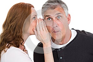 Woman telling secret to her partner photo