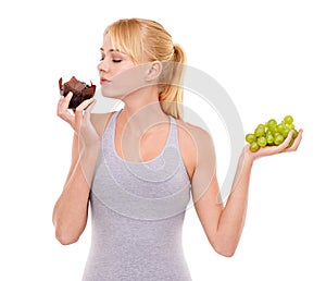 Woman, temptation and dessert over fruit in studio with white background in backdrop. Girl, choice and decision between