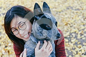 Woman Tenderly Hugging and looking at her Pet Australian doggy