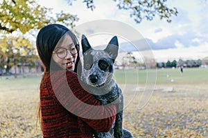 Woman Tenderly Hugging and looking at her Pet Australian doggy