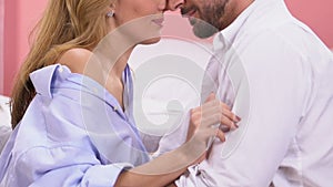 woman tenderly stroking man hand, intimacy and temptation in bedroom