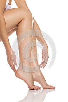 Woman tenderly touching her feet photo