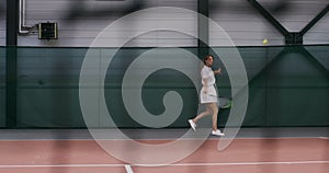 A woman tennis player plays tennis, hitting the ball over and over again