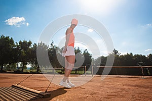 Woman tennis player preparing a tennis court before her match, sport concept