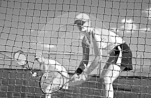 Woman tennis players looking at camera through net waiting to play while looking at camera