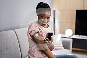 Woman Testing Glucose Level With Continuous Glucose Monitor