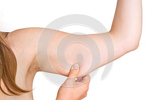 Woman is testing her muscle under her arm