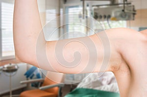 Woman is testing her muscle under her arm