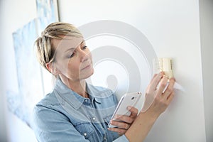 Woman testing the thermostat temperature