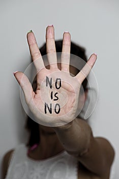 Woman with the text no is no written in her palm