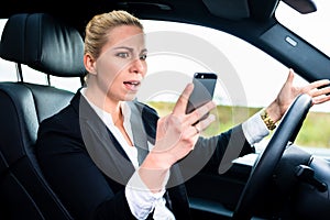 Woman texting while driving by car