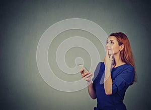 Woman texting on her mobile phone looking up planning